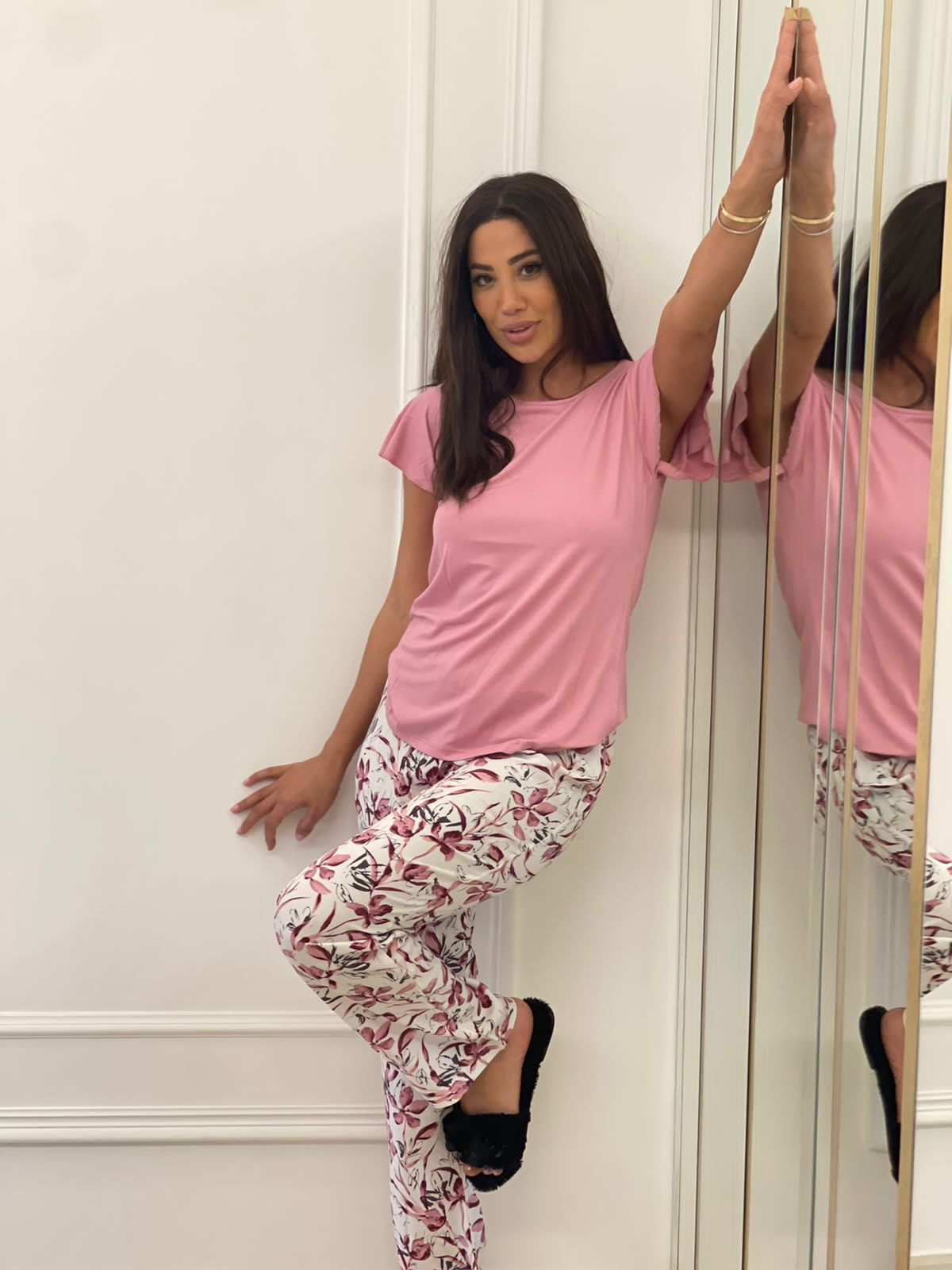 Model wearing a Popjammies lilac flutter sleeve pyjama set, featuring a soft lilac top and white pants with a pink and navy floral print, posing against a mirrored wall.