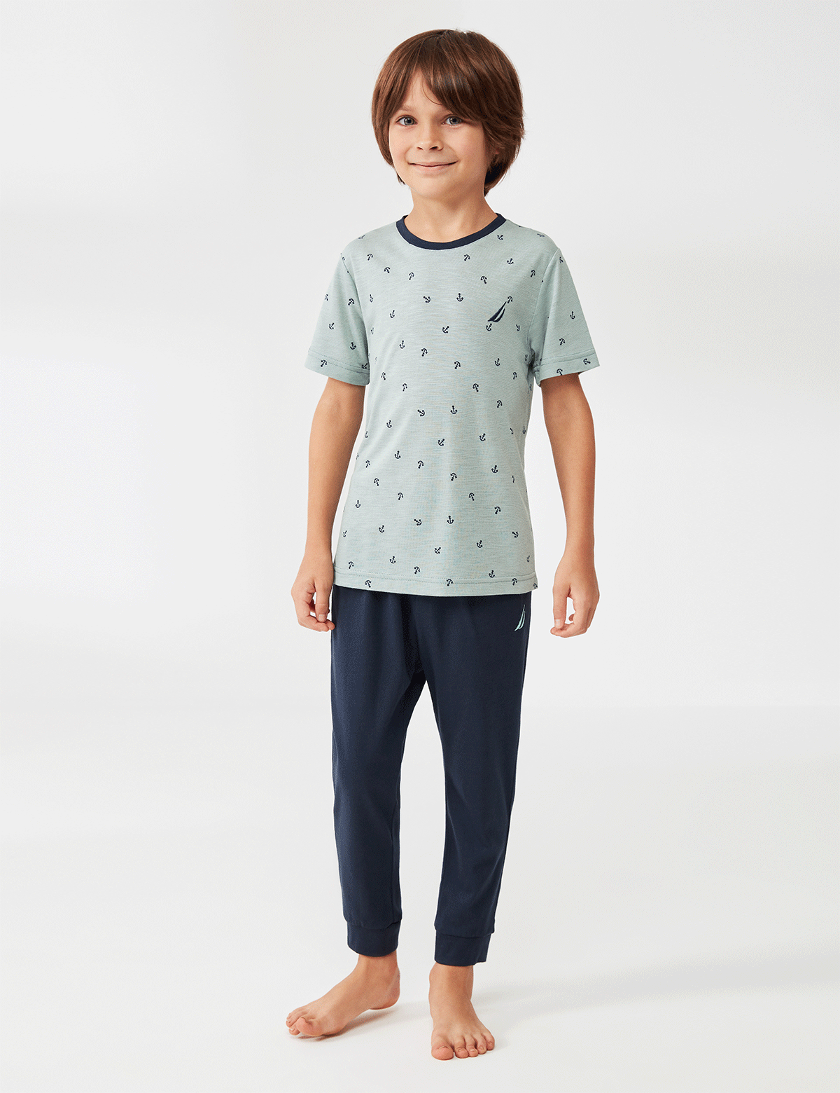 Boy wearing a light blue t-shirt with anchor print and navy blue pants from Popjammies.