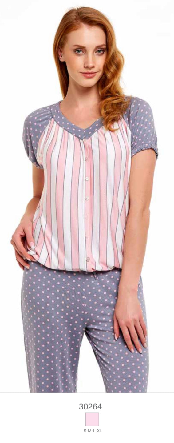 Woman wearing a Popjammies pyjama set with a pink and white striped button-down top and grey polka dot pants.